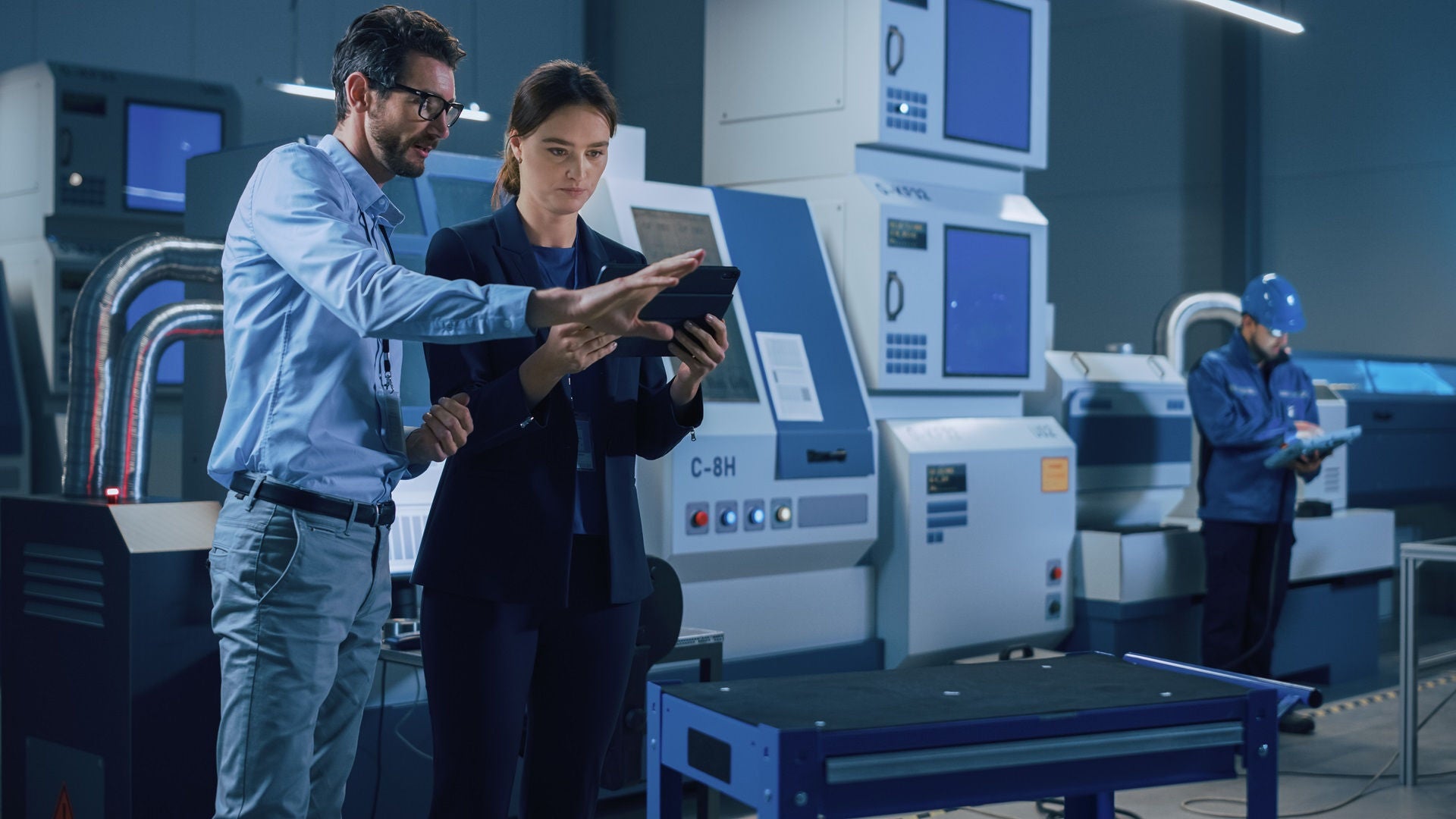 Portrait of Two Professional Engineers Use Industrial Digital Tablet to Work with Augmented Reality. Great Template Shot for Augmented Reality. Factory Workshop with CNC Machinery.